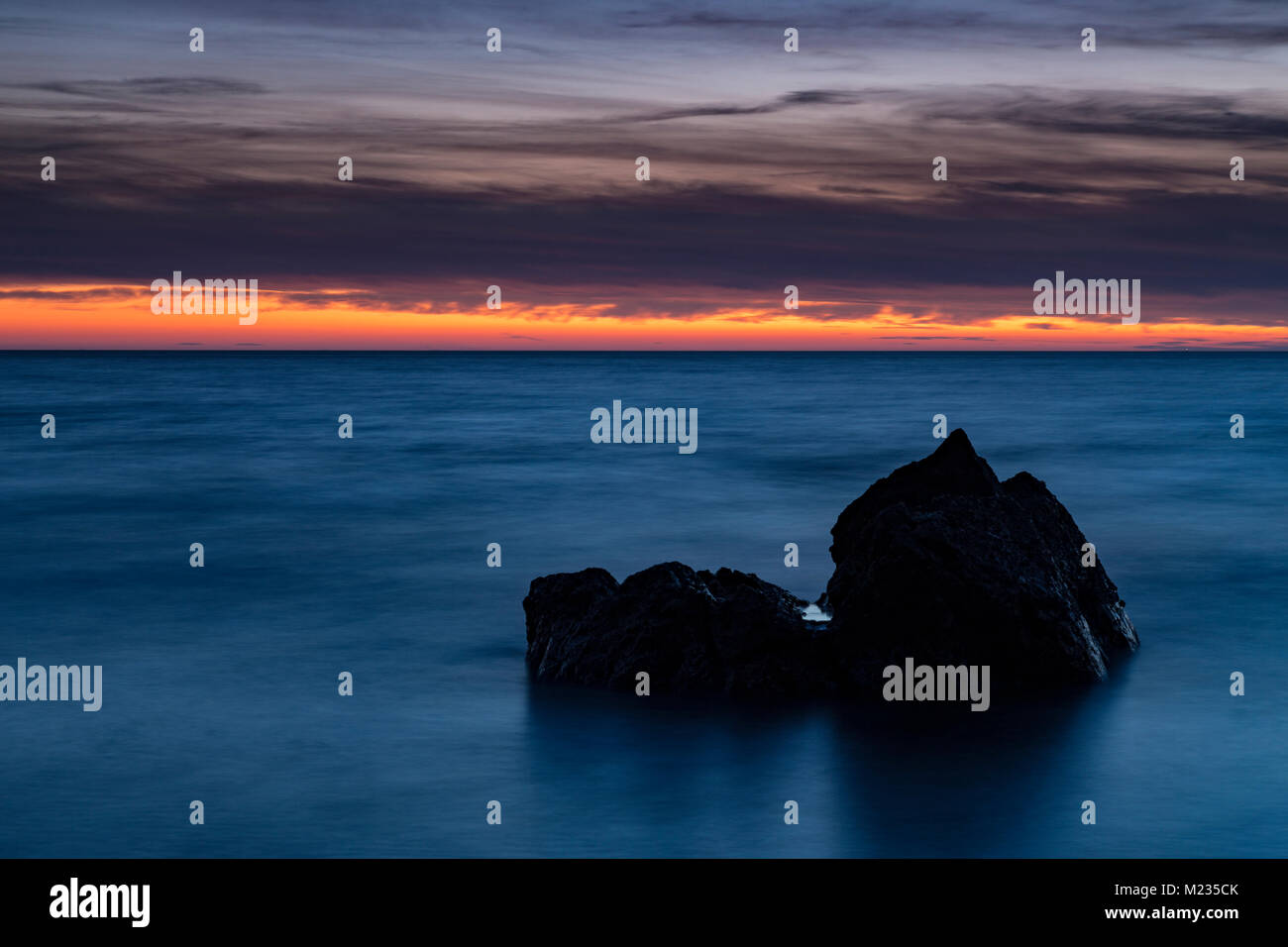 Rock in the sea at twilight on the North Wales coast, Church Bay, Angelsey Stock Photo