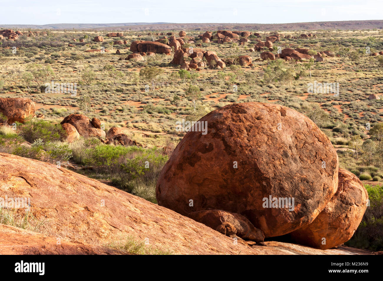 Devils Marbles are huge granite boulders scattered across a wide valley, 100 kilometers south of Tennant Creek in the Northern Territory, Australia. Stock Photo