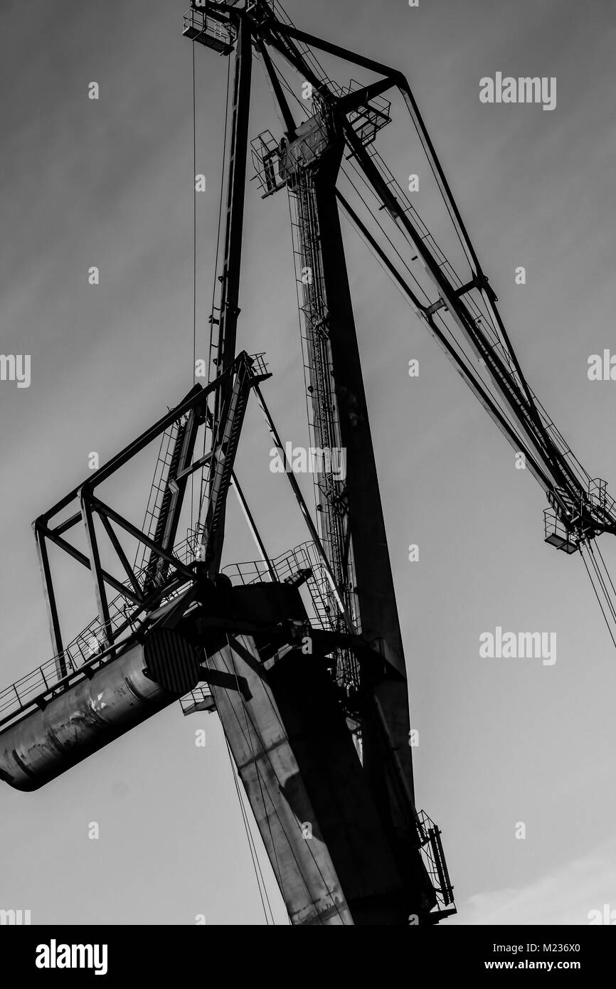 Gdansk shipyard, Poland. Retro style black and white. Cranes, old shipyard buildings, rusty structures. Stock Photo