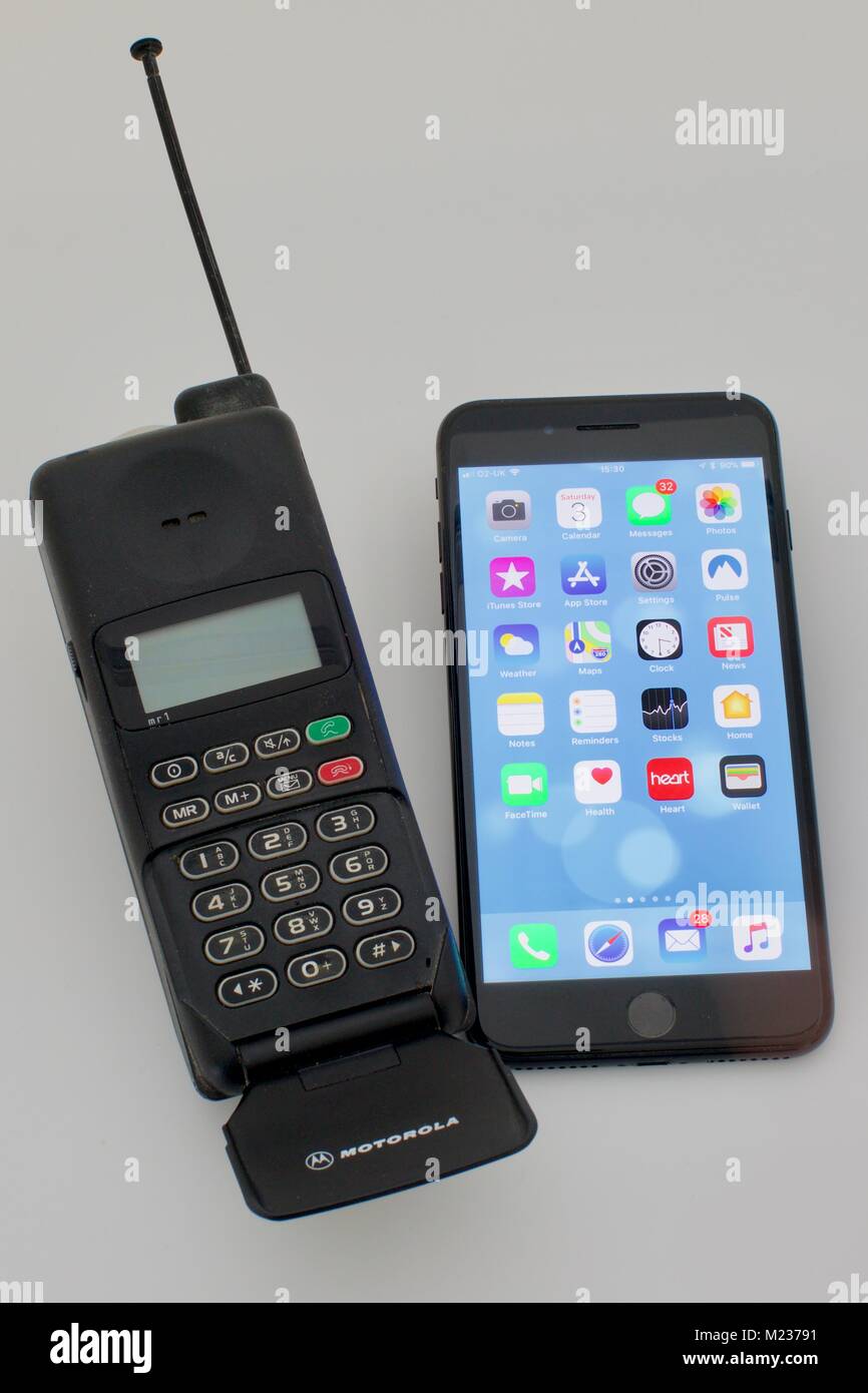 Apple iPhone 7 Plus next to an old fashioned Motorola handset from the nineties Stock Photo