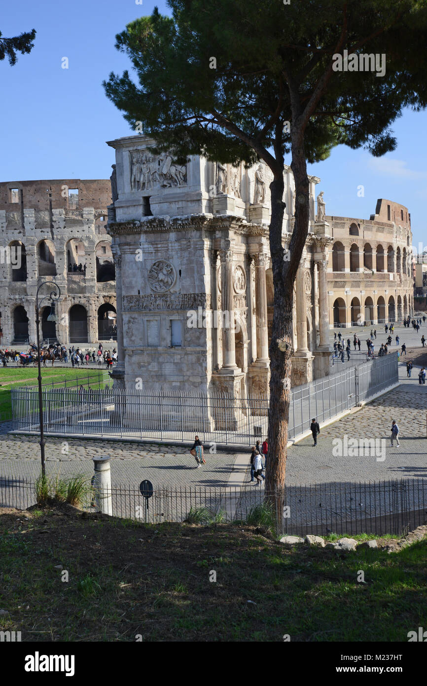 Portrait view showing the side of the Archway of Constantine from the Palatine with the Colosseum behind it in Rome, Italy Stock Photo