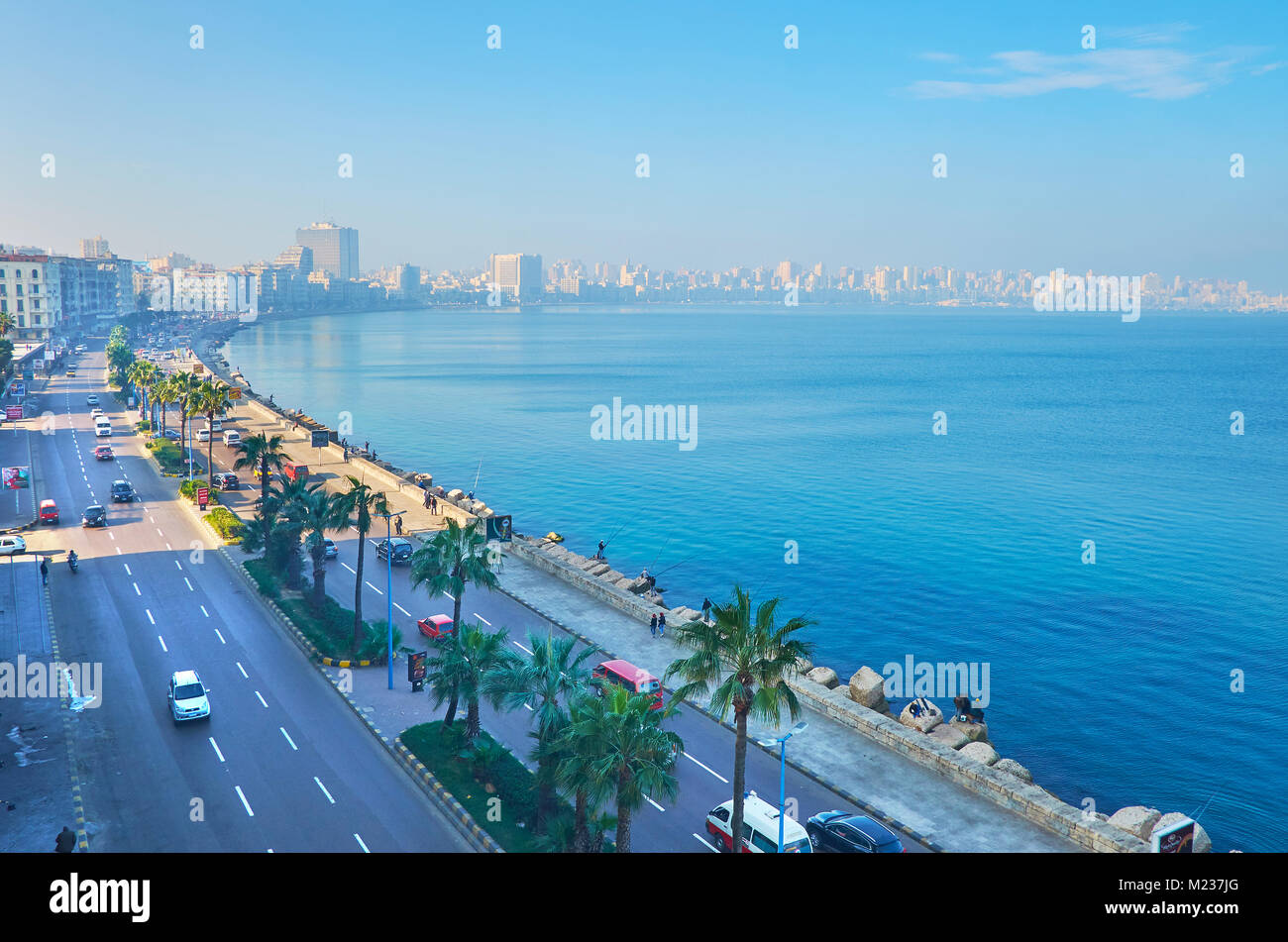 ALEXANDRIA, EGYPT - DECEMBER 18, 2017: The heavy traffic along the Corniche embankment, the buildings of city center are seen through the morning haze Stock Photo