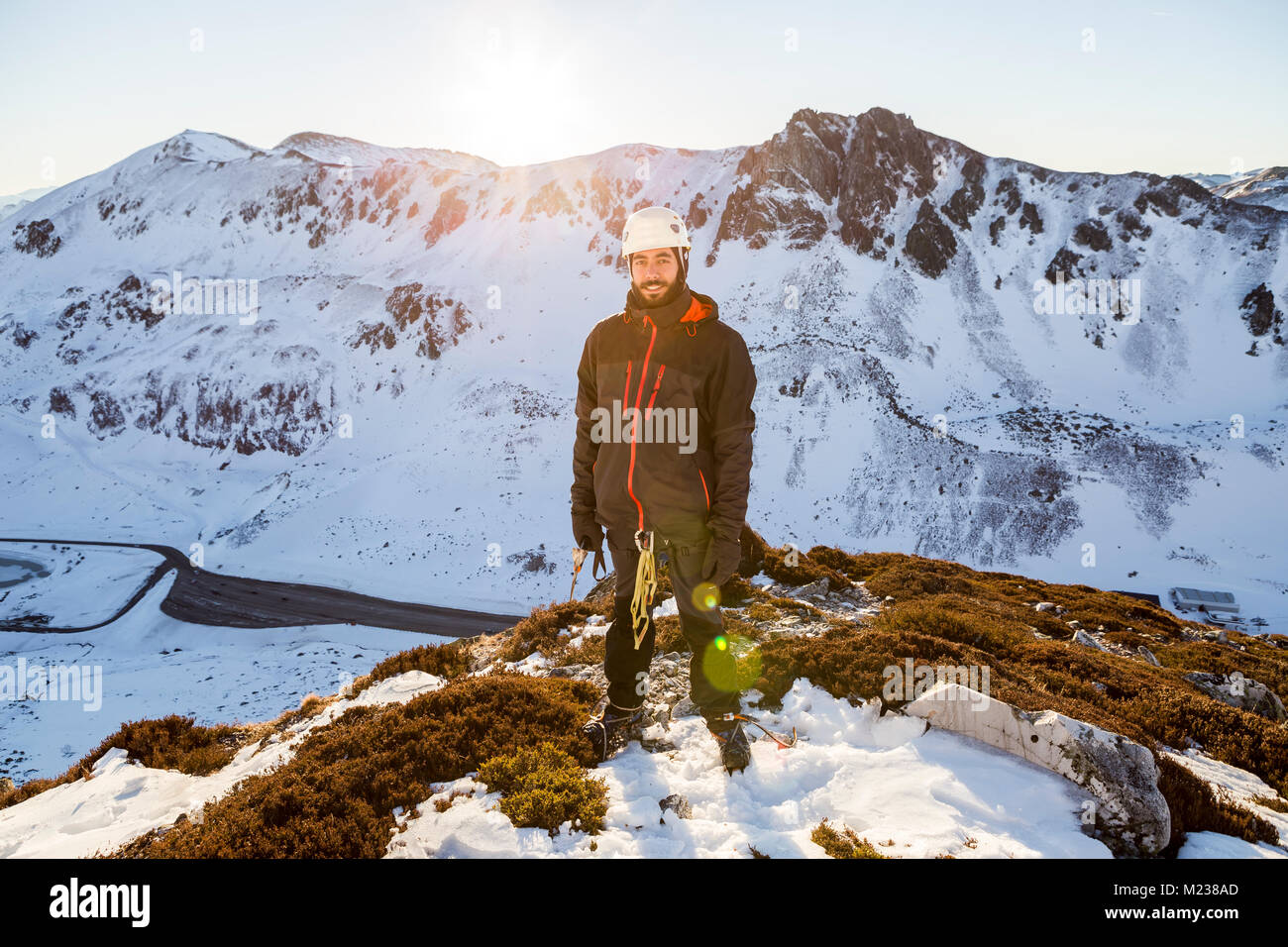 One young man on top a snowy mountain wearing alpinism gear Stock Photo