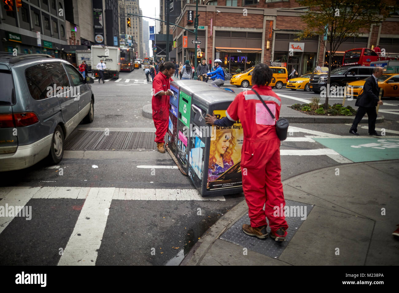 New York City Manhattan, Times Square street cleaners moving a recycling trash bins Stock Photo