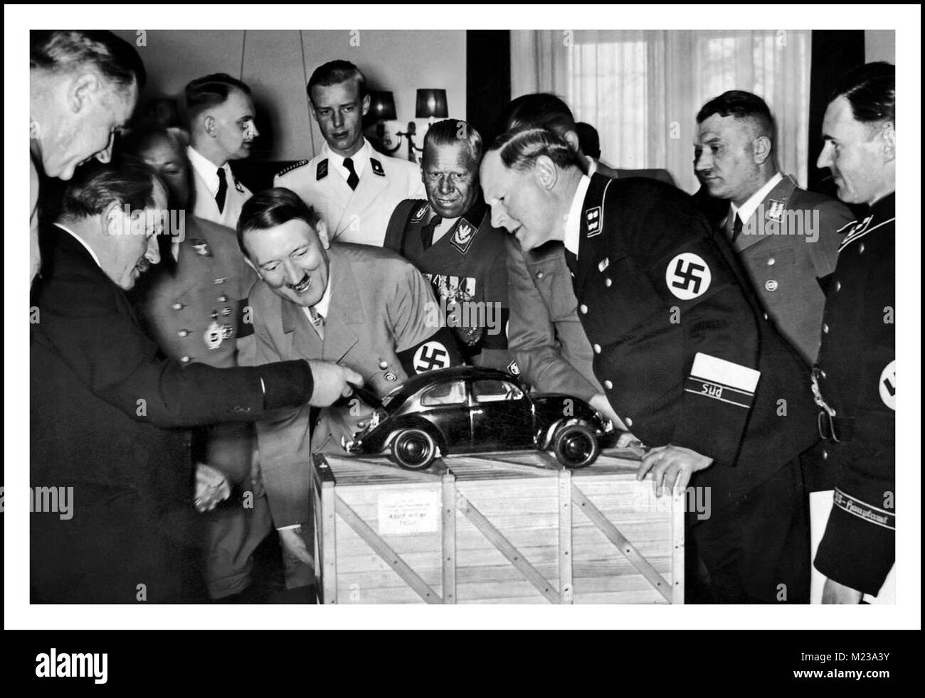 HITLER VOLKSWAGEN KDF-WAGEN 1930’s Dr Porsche showing Fuhrer Adolf Hitler and senior Nazi officials, a scale model of his unique air cooled engine and inspired design... ‘the people’s car’, the Volkswagen ‘Beetle’ KDF Wagen Fallersleben Wolfsburg Germany  Archive Nazi propaganda image Stock Photo