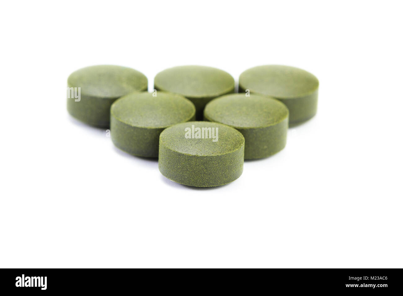 close up of a group of fermented chlorella tablets isolated on a white