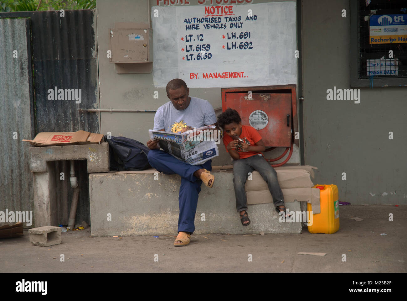 Father and son who is eating ice cream, Pacific Harbour, Fiji. Stock Photo