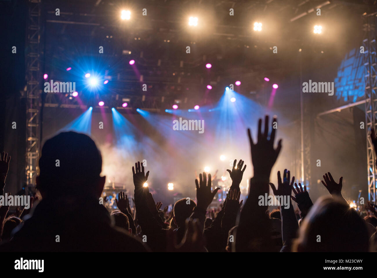 Christians raising their hands in praise and worship at a night music concert Stock Photo