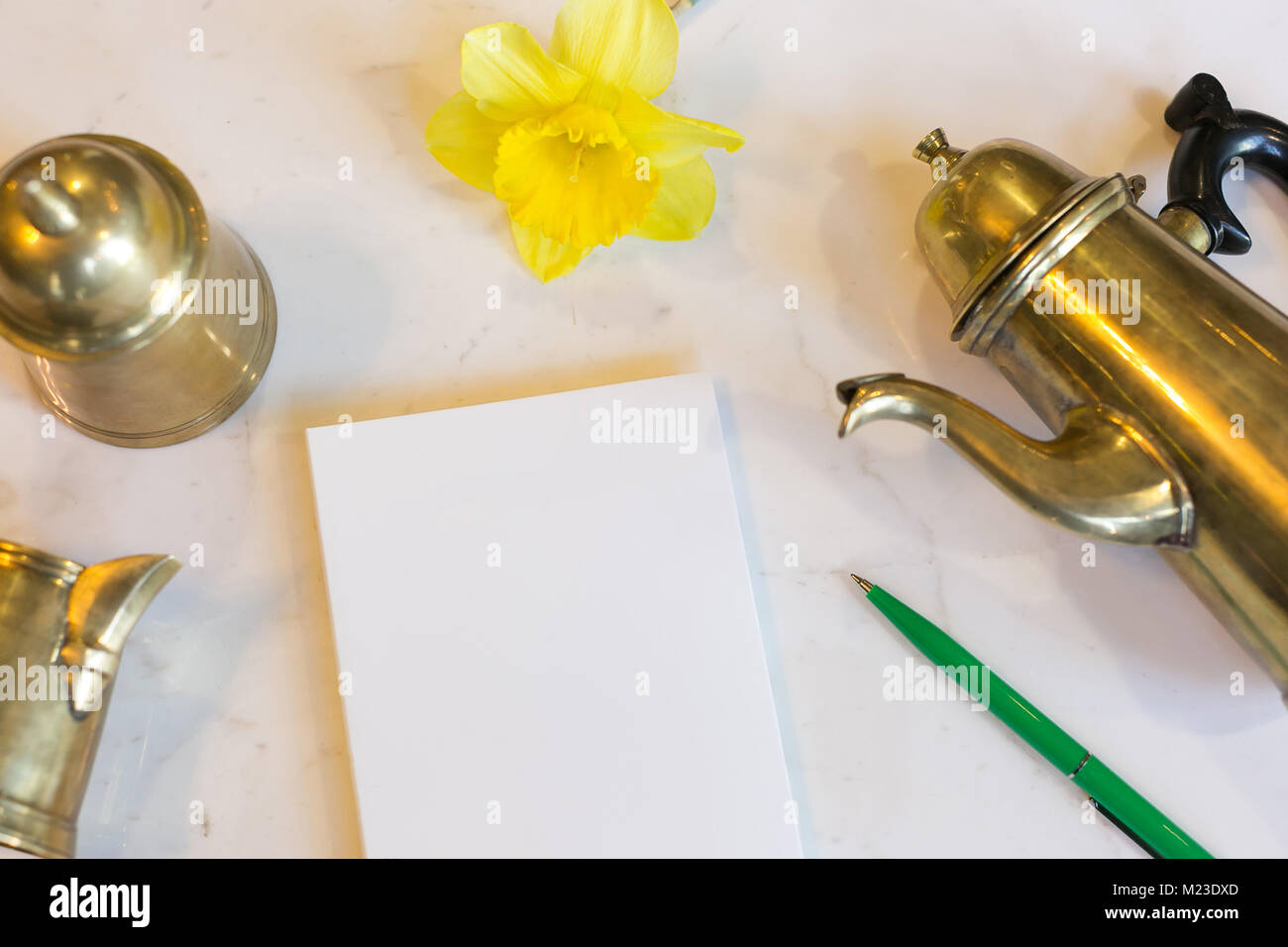drawing, tea ceremony, rest concept. on the marble table there is vintage bronze teapot and small bell made of the same material, they are placed by s Stock Photo