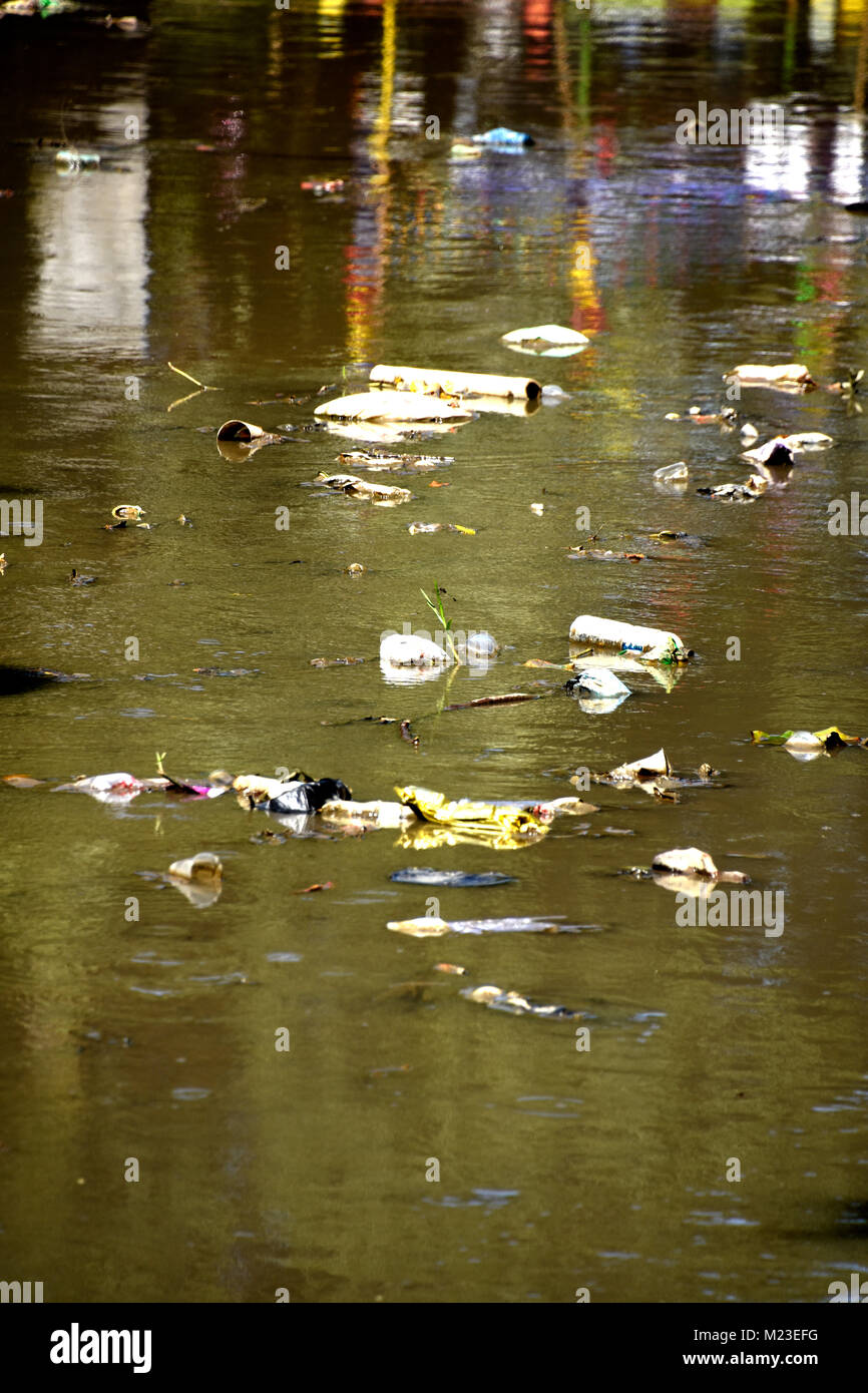 Rubbish flowing down a small river in Indonesia, next to a slum area called the painted village Stock Photo