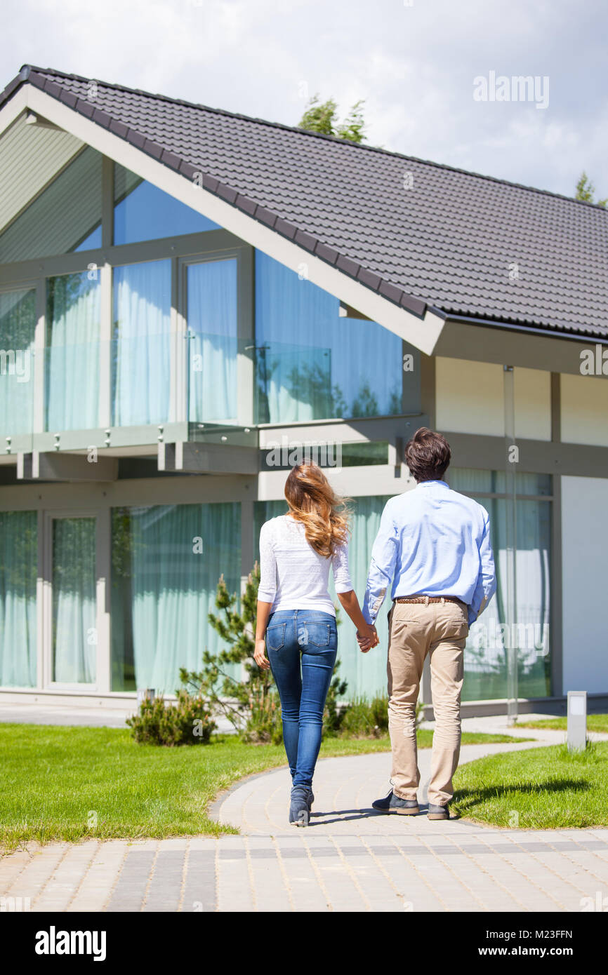 Happy couple walking outdoors near their house Stock Photo