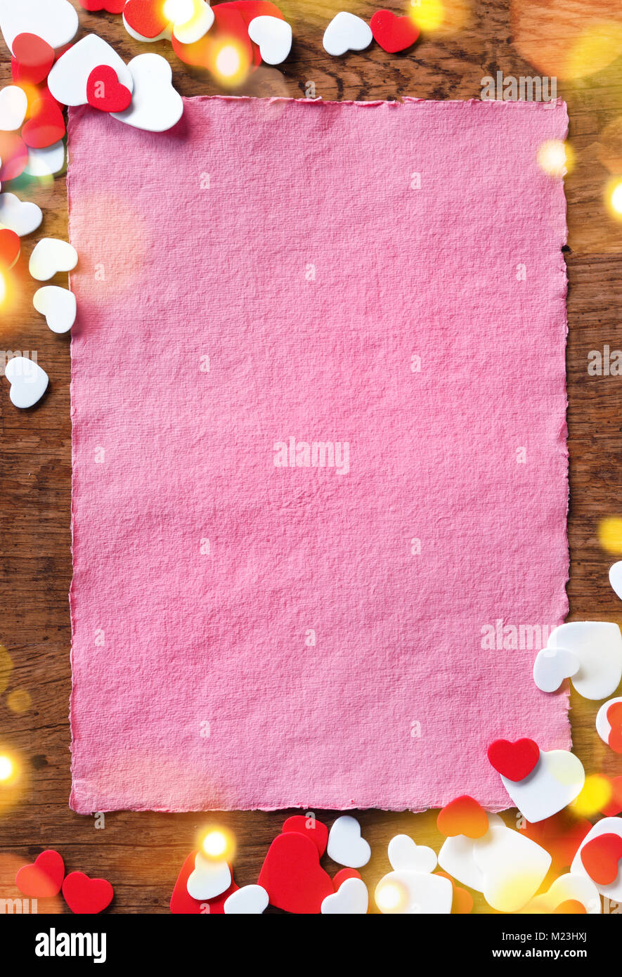 Pink letter with heap of small hearts on wooden background. Copy space for your text Stock Photo