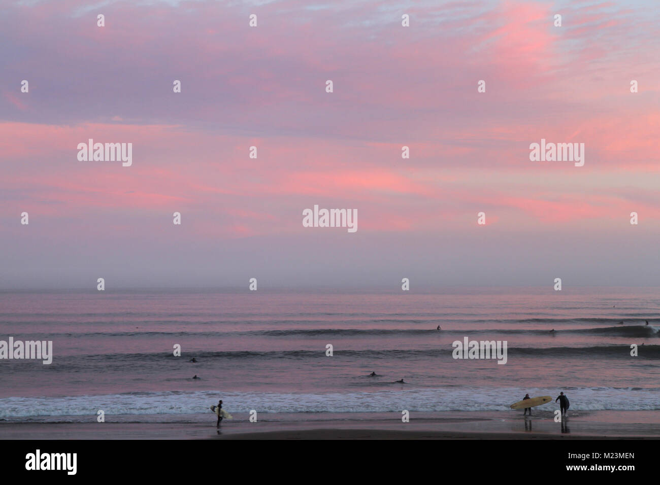 Surfers at sunset on Cowell's Beach, Santa Cruz, California, United States Stock Photo