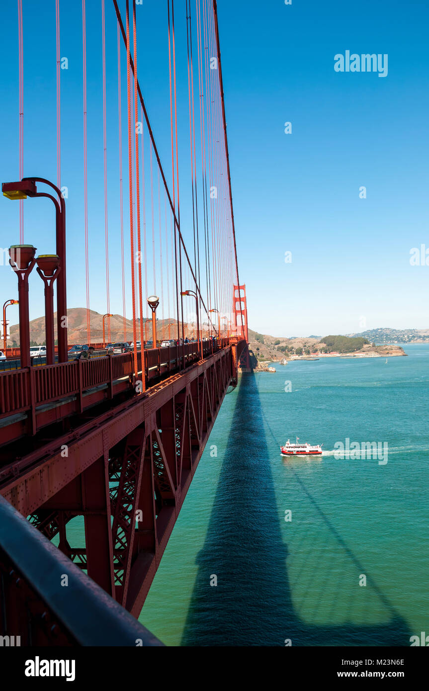 SAN FRANCISCO, CALIFORNIA - SEPTEMBER 8, 2015 - Golden Gate Bridge with pedestrians crossing and boat passing under Stock Photo