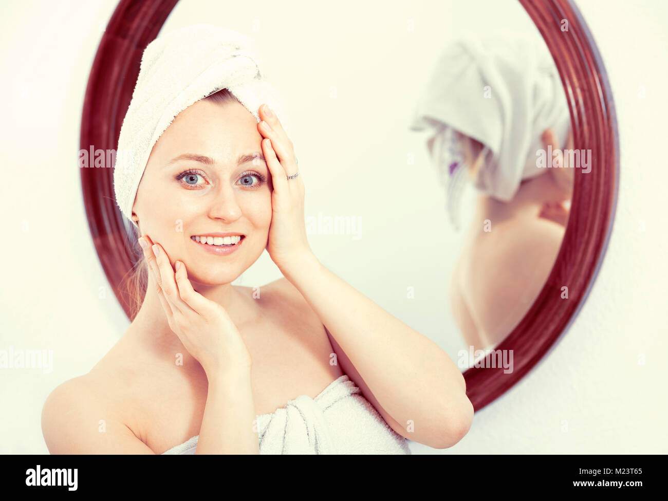 Cheerful Woman Wearing A Towel After Shower Looking At Herself In The