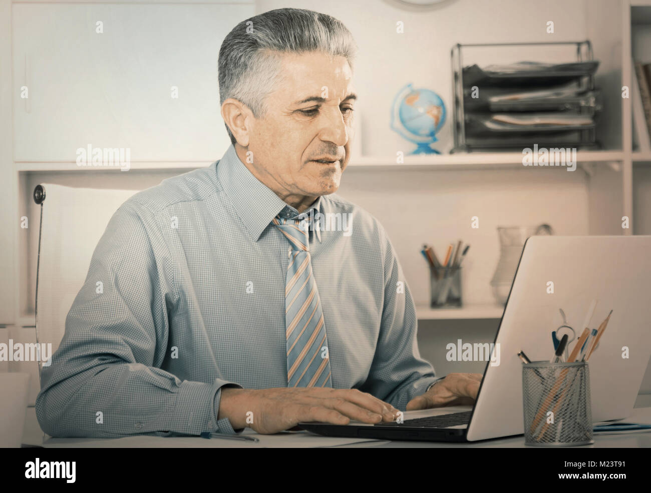 Mature lawyer preparing important documents on computer at legal