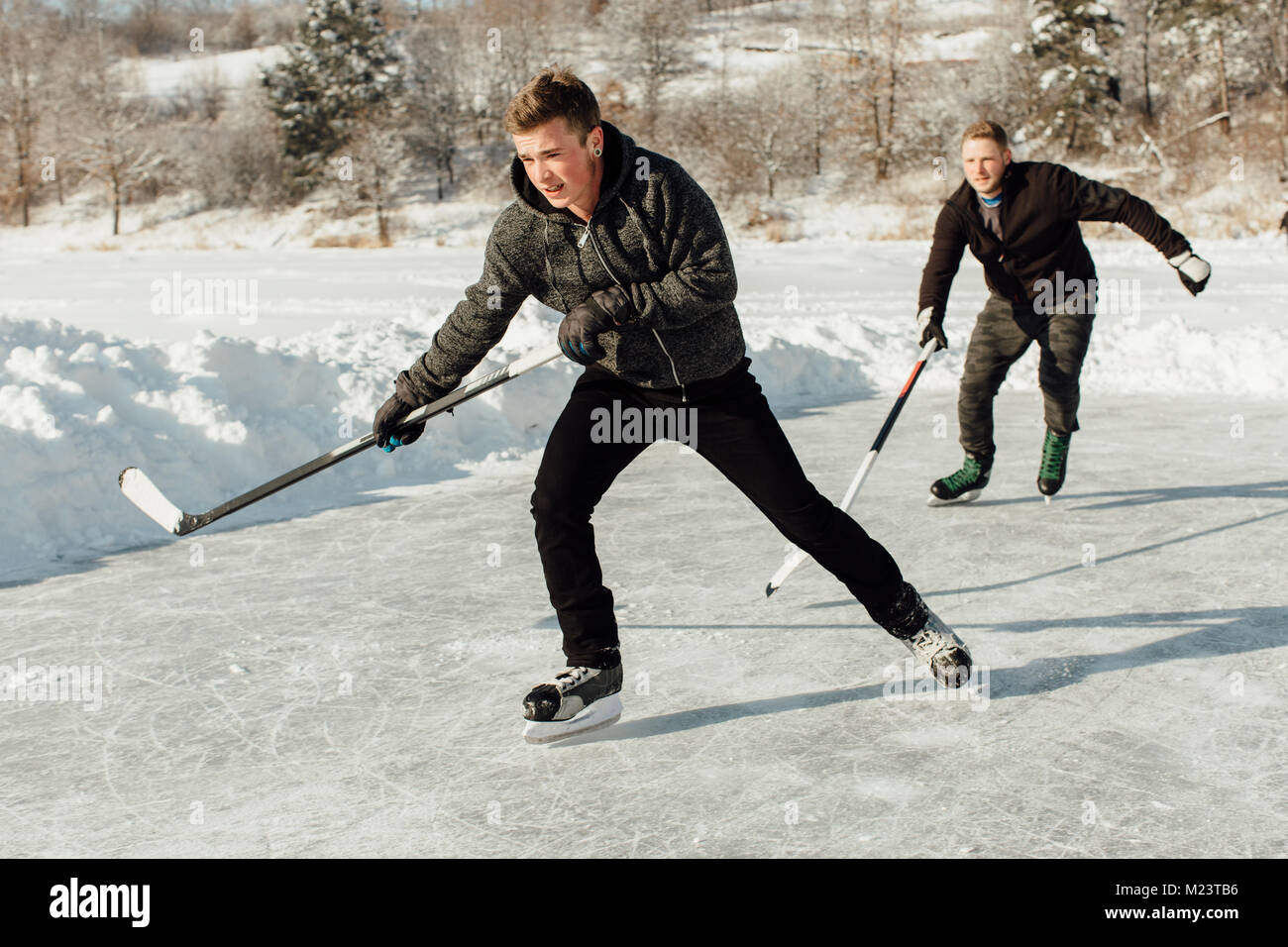 Two men playing ice hockey on a frozen lake Stock Photo Alamy
