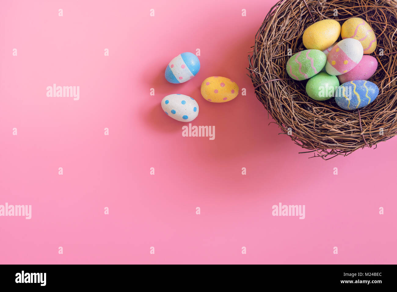 Colorful easter eggs in nest on pink pastel color background with space ...
