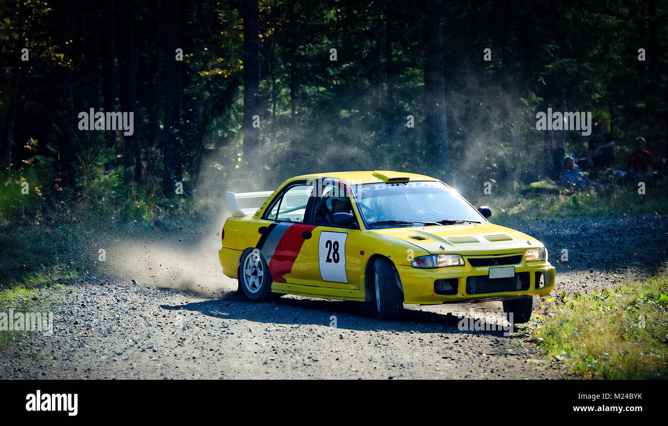 A yellow Mitsubishi drifting in a corner in a rally Stock Photo
