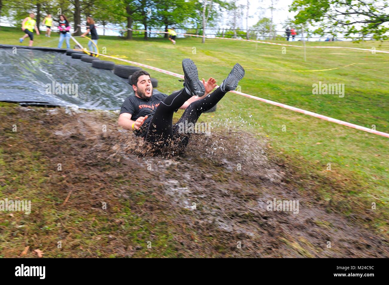 OVIEDO, SPAIN - MAY 9: Storm Race, an extreme obstacle course in May 9, 2015 in Oviedo, Spain. Runner sliding down a water slide Stock Photo