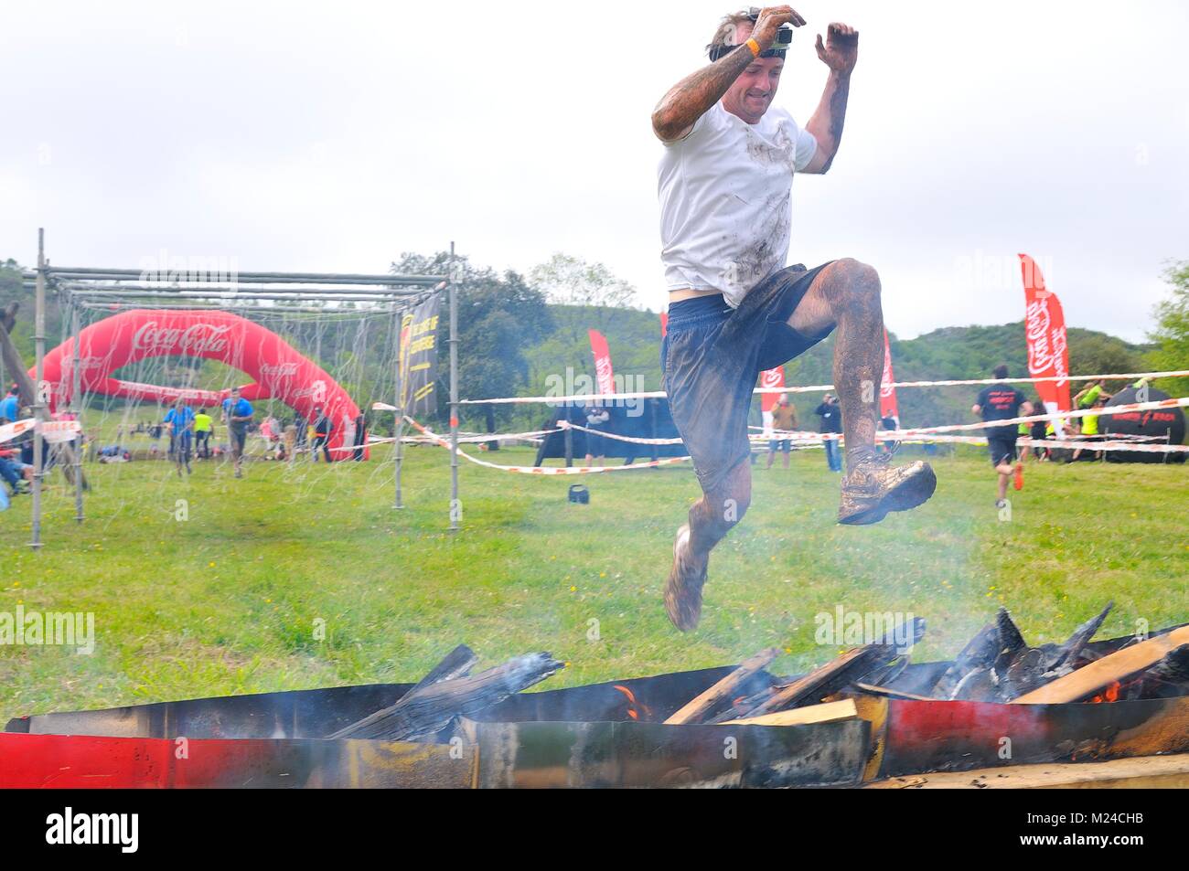 OVIEDO, SPAIN - MAY 9: Storm Race, an extreme obstacle course in May 9, 2015 in Oviedo, Spain. Runners jumping a barrier of fire. Stock Photo