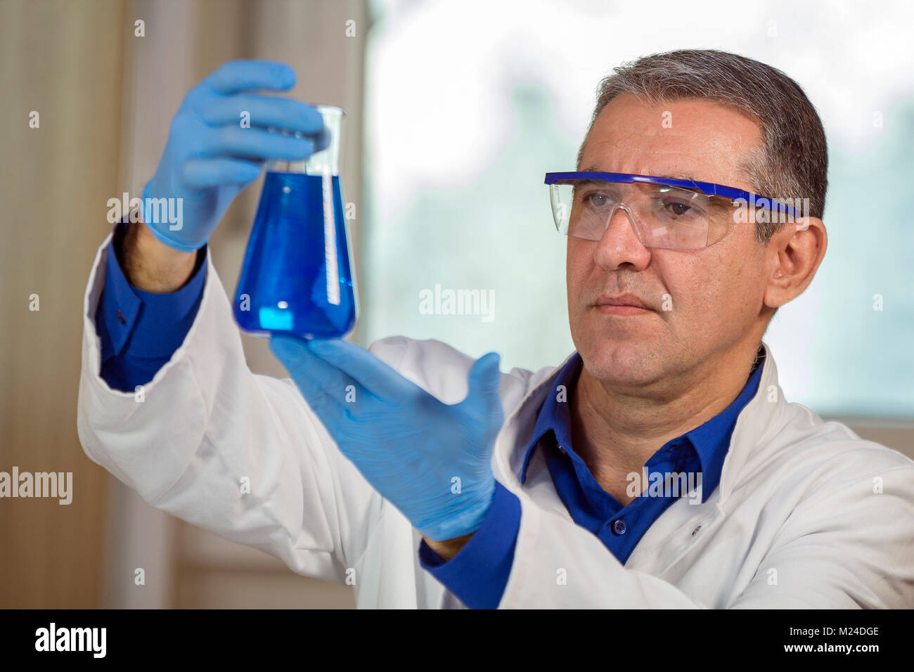 Scientist wearing protective gear, working in laboratory. Stock Photo