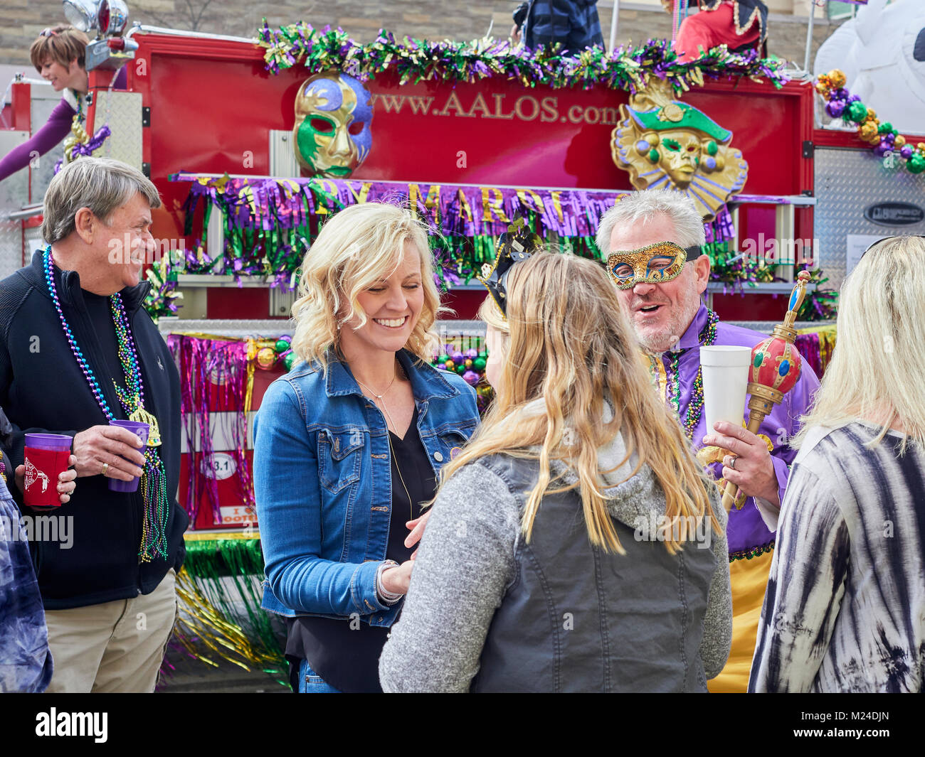 Family celebrating Mardi Gras with mother, and daughter with the father wearing a Mardi Gras mask and holding a scepter in Montgomery Alabama, USA. Stock Photo