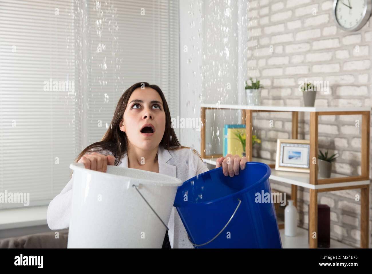 Worried Woman Holding Two Buckets While Water Droplets Leaking From