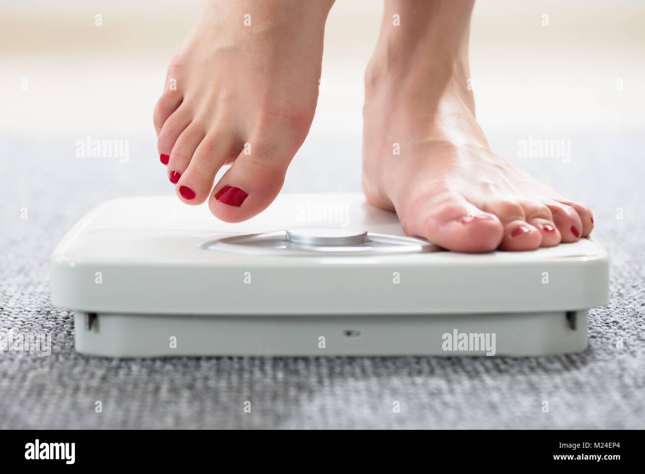 Closeup Of A Woman's Feet On Weighing Scale Over The Carpet Stock