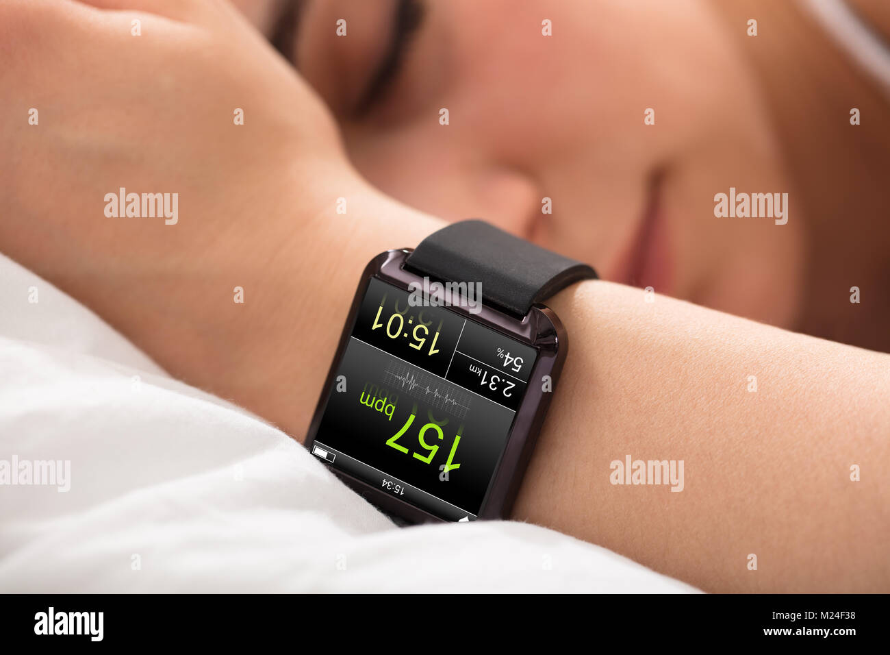 Smart Watch Showing Heartbeat Rate On Sleeping Woman's Hand Stock Photo