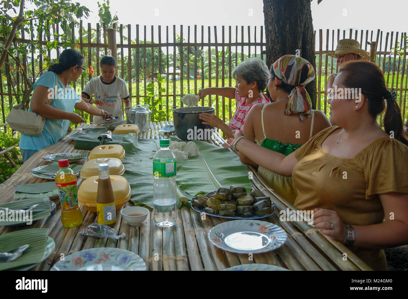 A group of ladies serving out food at a celebratory meal in Guimbal in the Philippines. Stock Photo