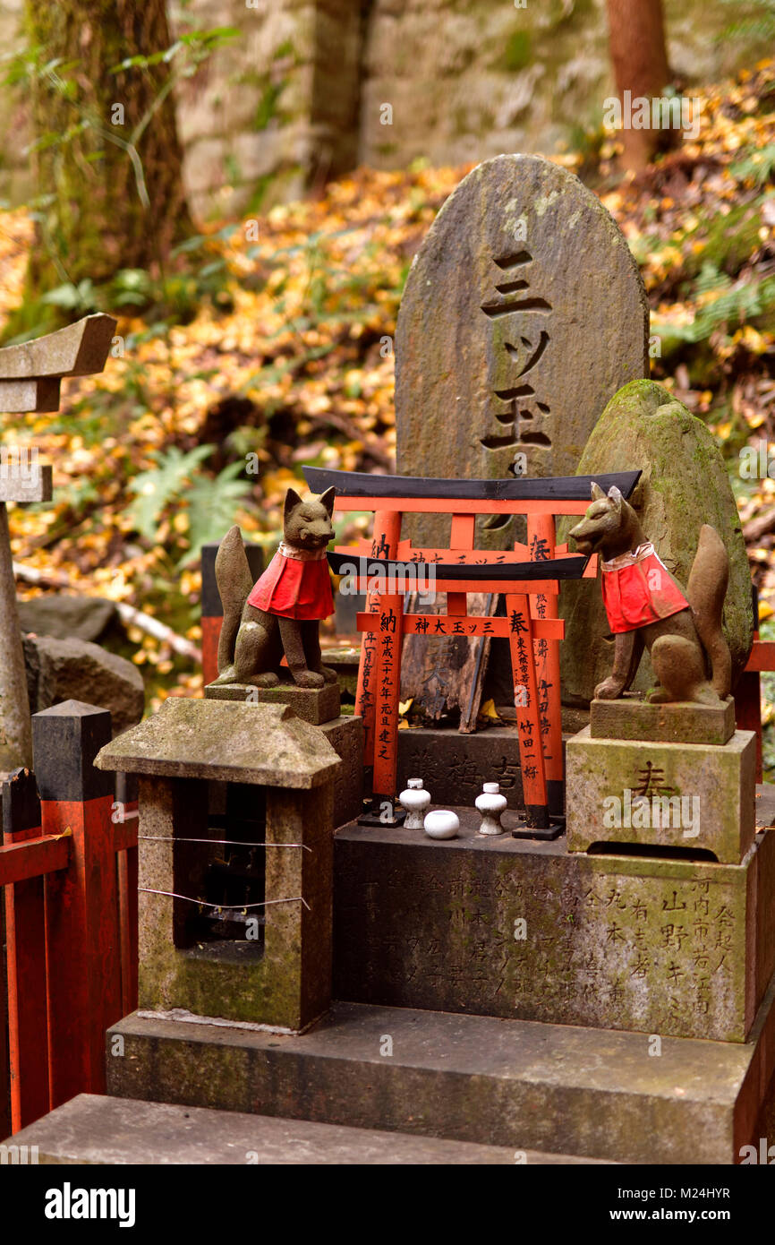 Private worship shrine altar, Tsuka, with Kitsune, messenger foxes. One of the thousands little Shinto shrines at Fushimi Inari Taisha head shrine in  Stock Photo