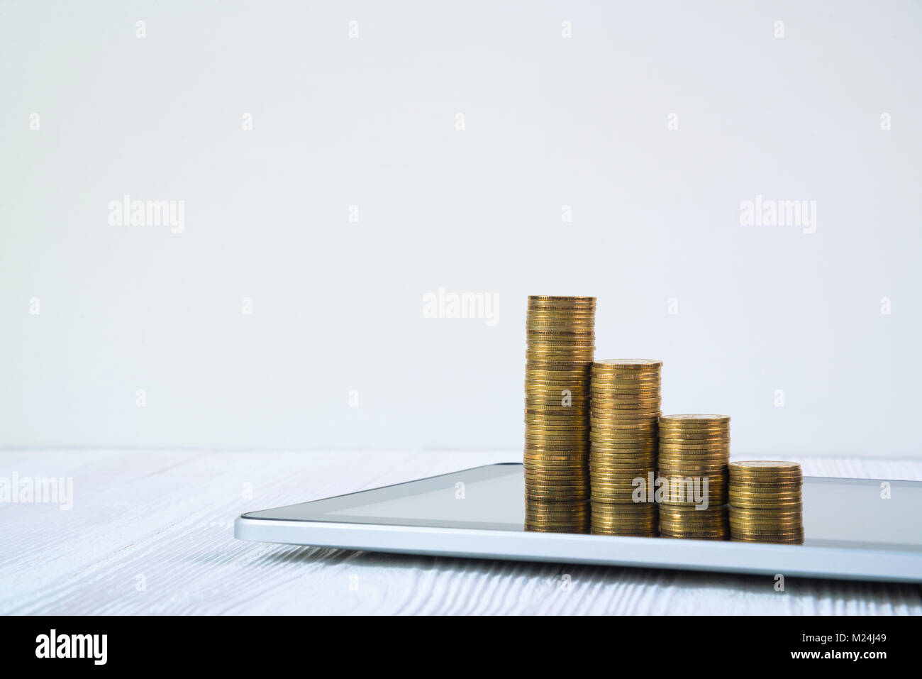 Coin Stack Arithmetic Program Step of coin stack on tablet computer screen on white working table ...
