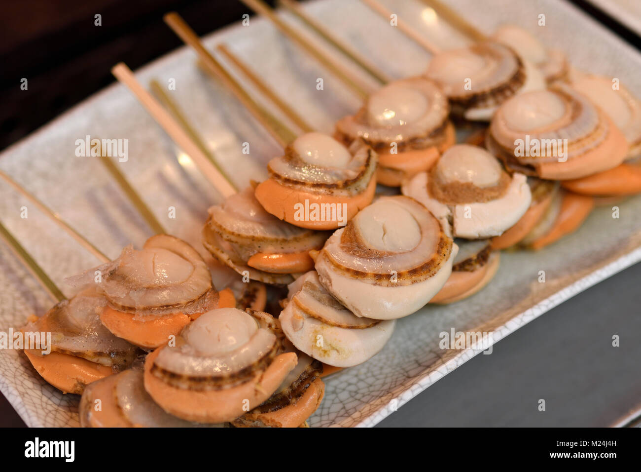 Japanese street food, grilled scallops, Hotateyaki, on a stick in