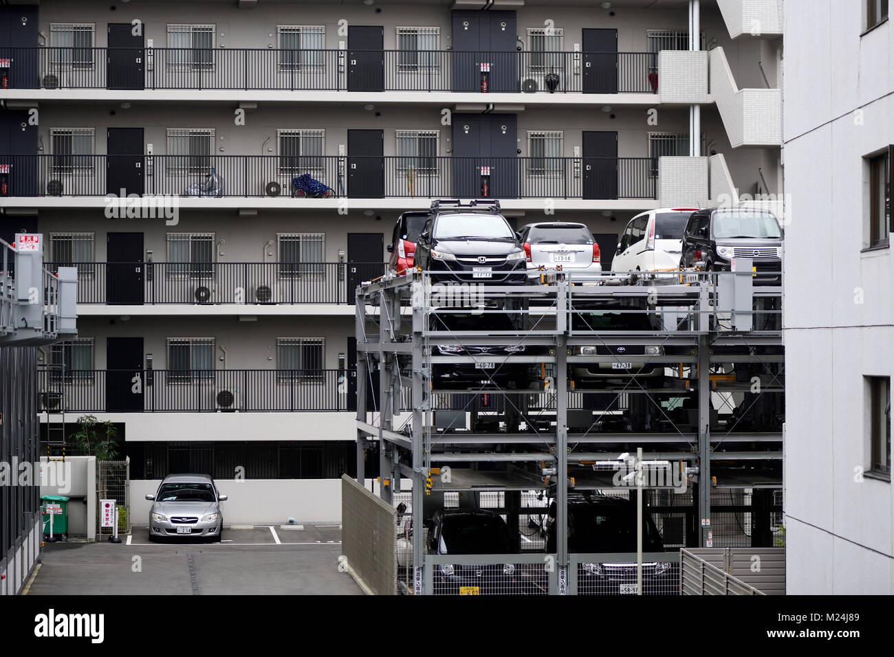 Multi-level vertical lift parking lot three stories high by an apartment building in Kyoto, Japan 2017 Stock Photo