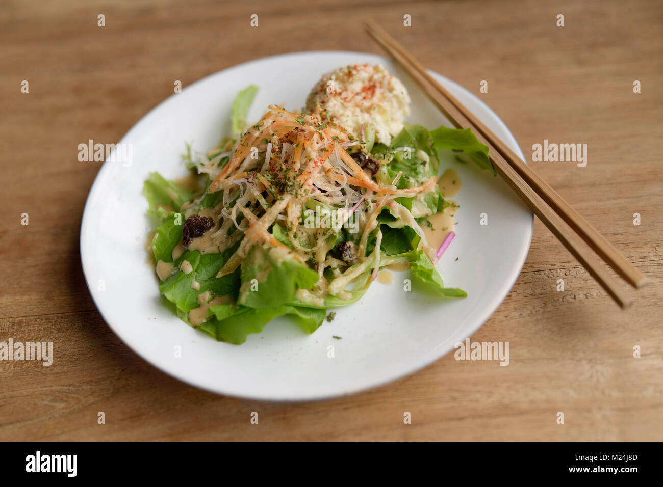A plate of vegetable salad in a Japanese vegan restaurant, food still life on a wooden table. Kyoto, Japan. Stock Photo