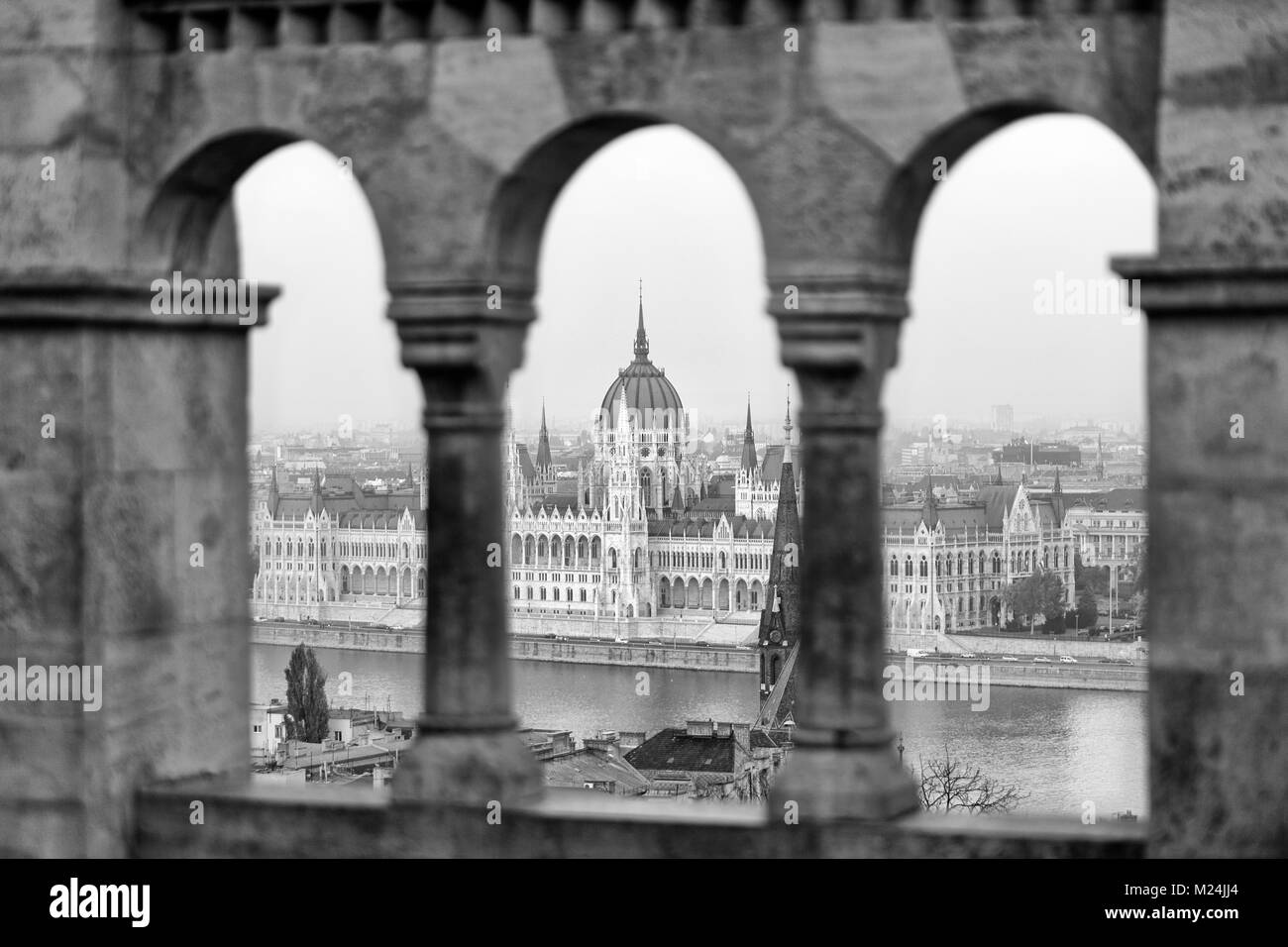 Országház (Hungarian Parliament Building) in Budapest, Hungary framed here by Budavári Palota (Buda Castle). Photographed in black and white. Stock Photo
