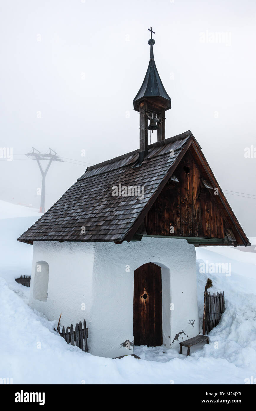 Little chapel and snow in the mountains Stock Photo
