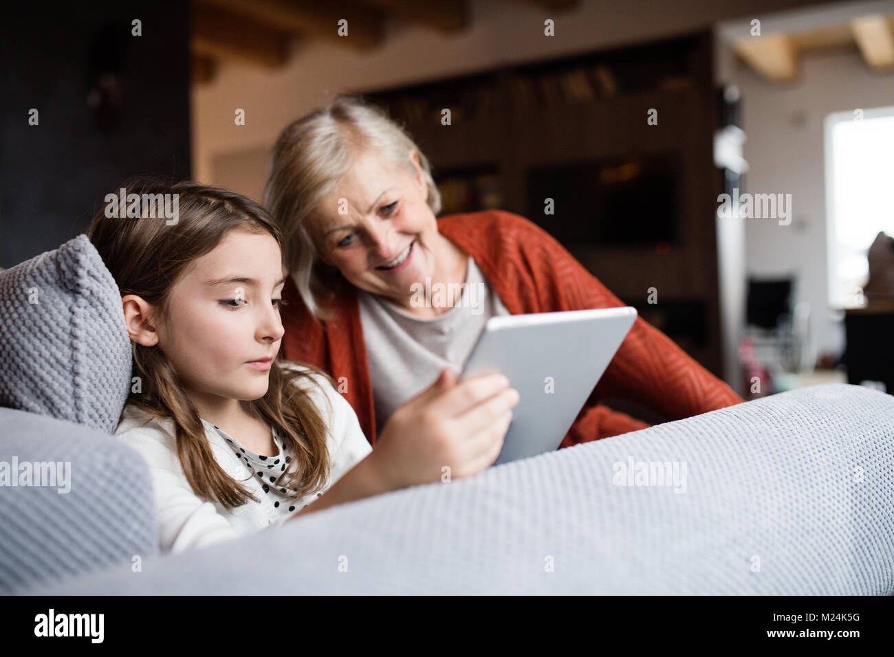 A small girl and grandmother with tablet at home Stock Photo - Alamy