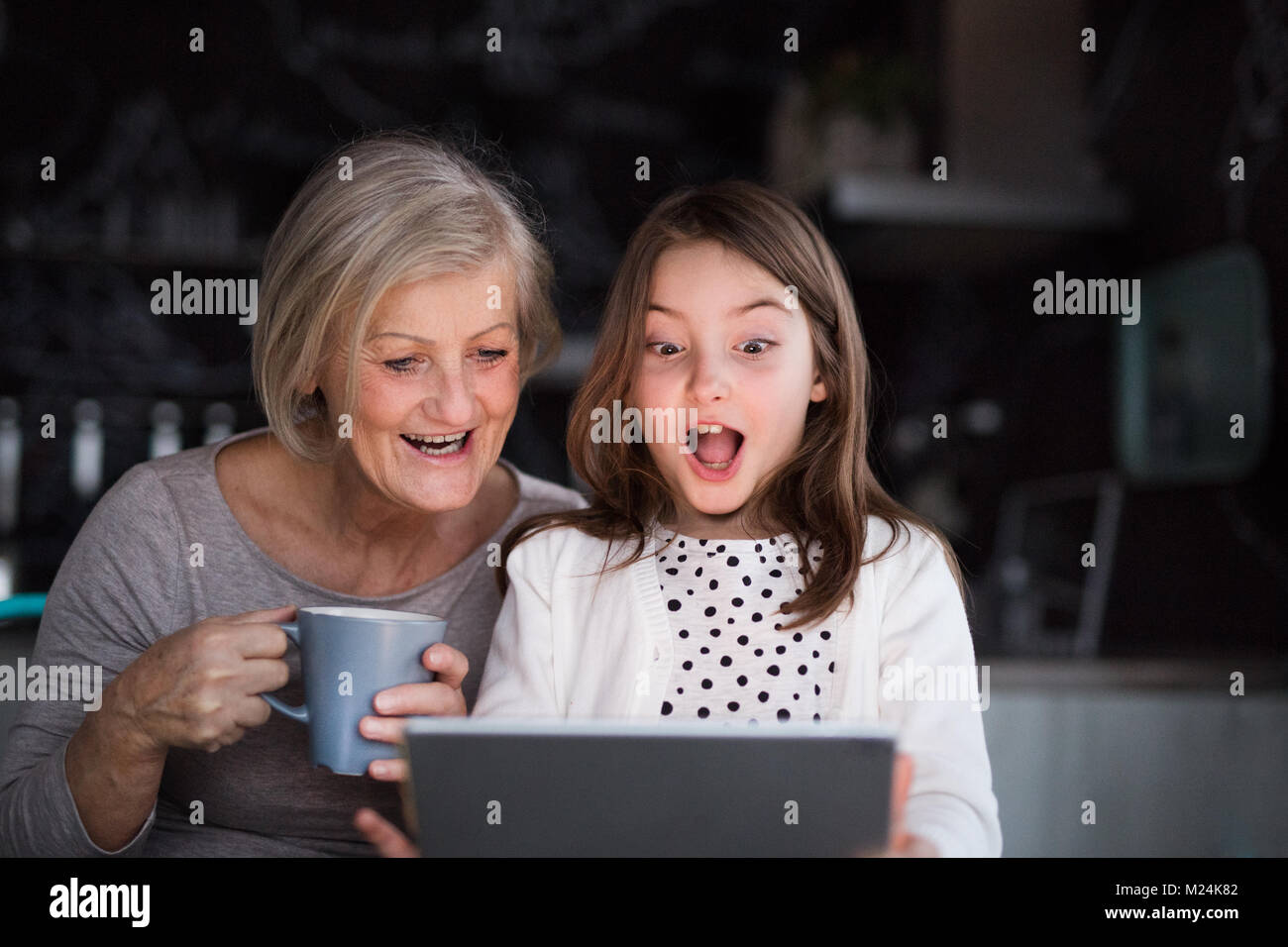 A small girl and grandmother with tablet at home Stock Photo - Alamy