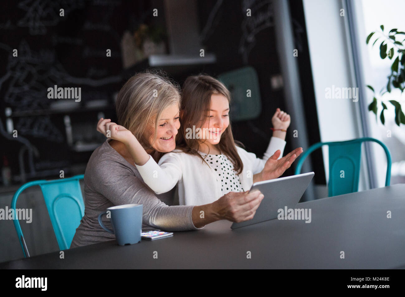 A small girl and grandmother with tablet at home Stock Photo - Alamy
