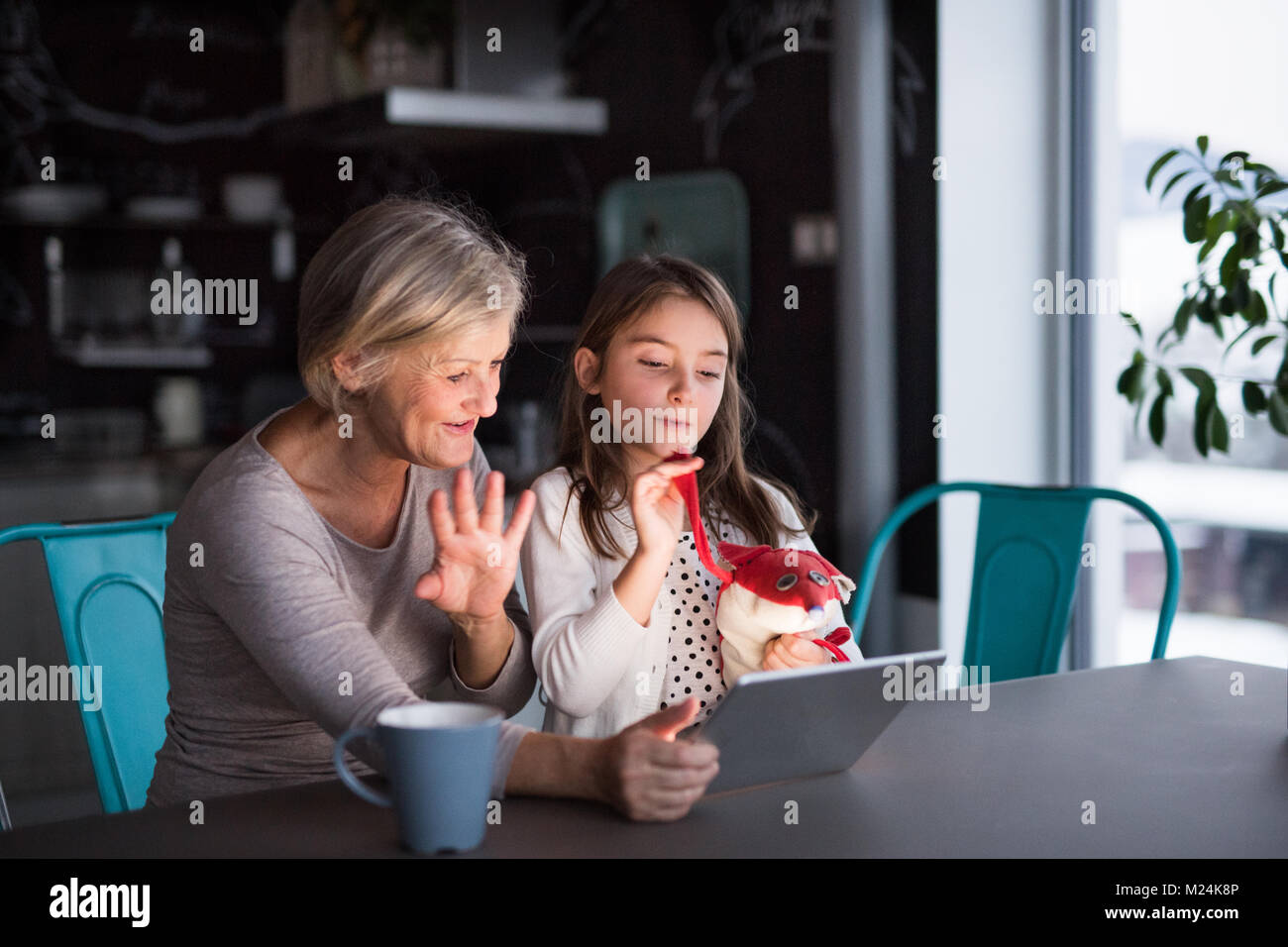 A small girl and grandmother with tablet at home Stock Photo - Alamy