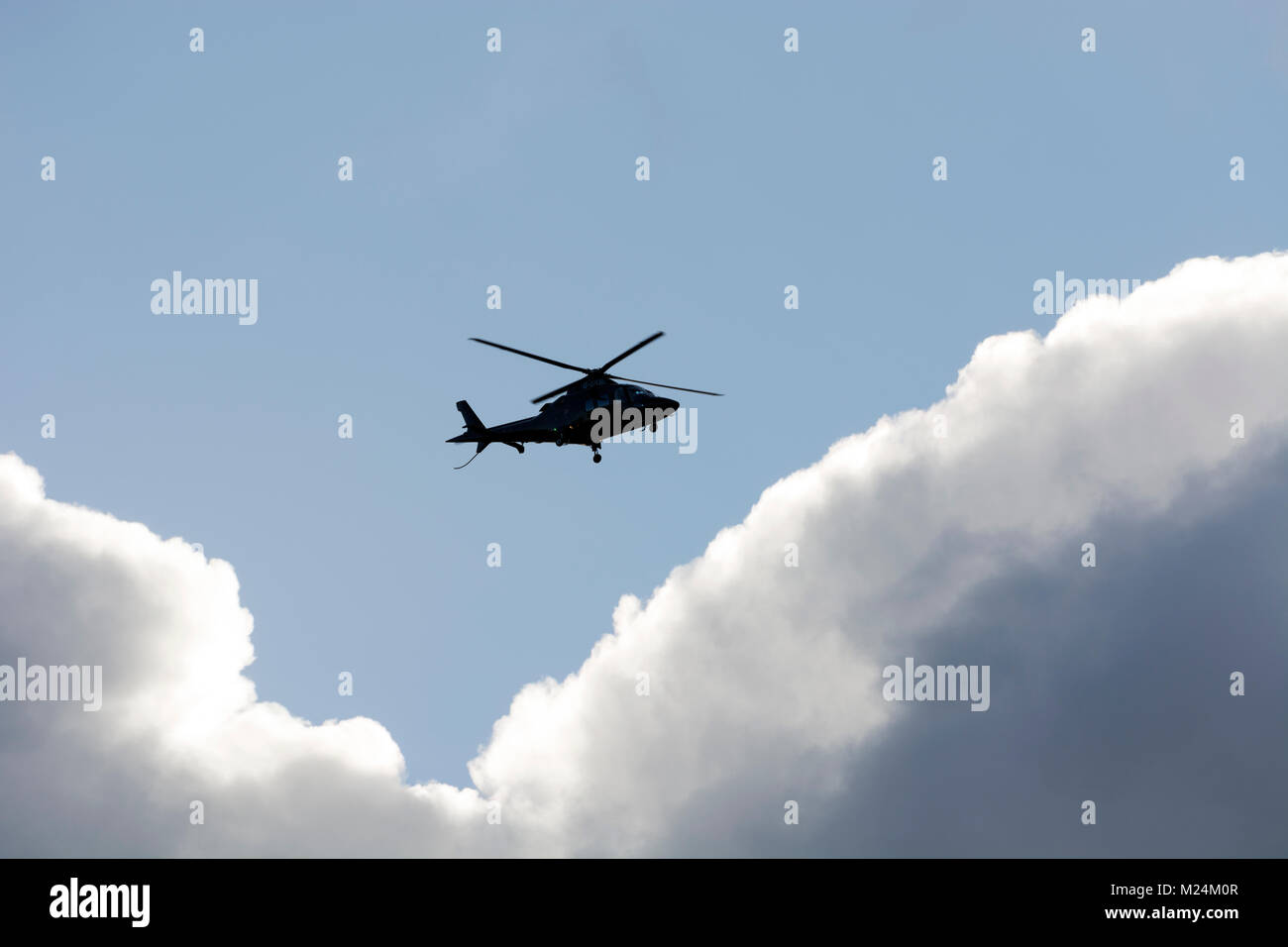 AugustaWestland AW109S helicopter, distant view over Birmingham Airport, UK (G-SKBL) Stock Photo