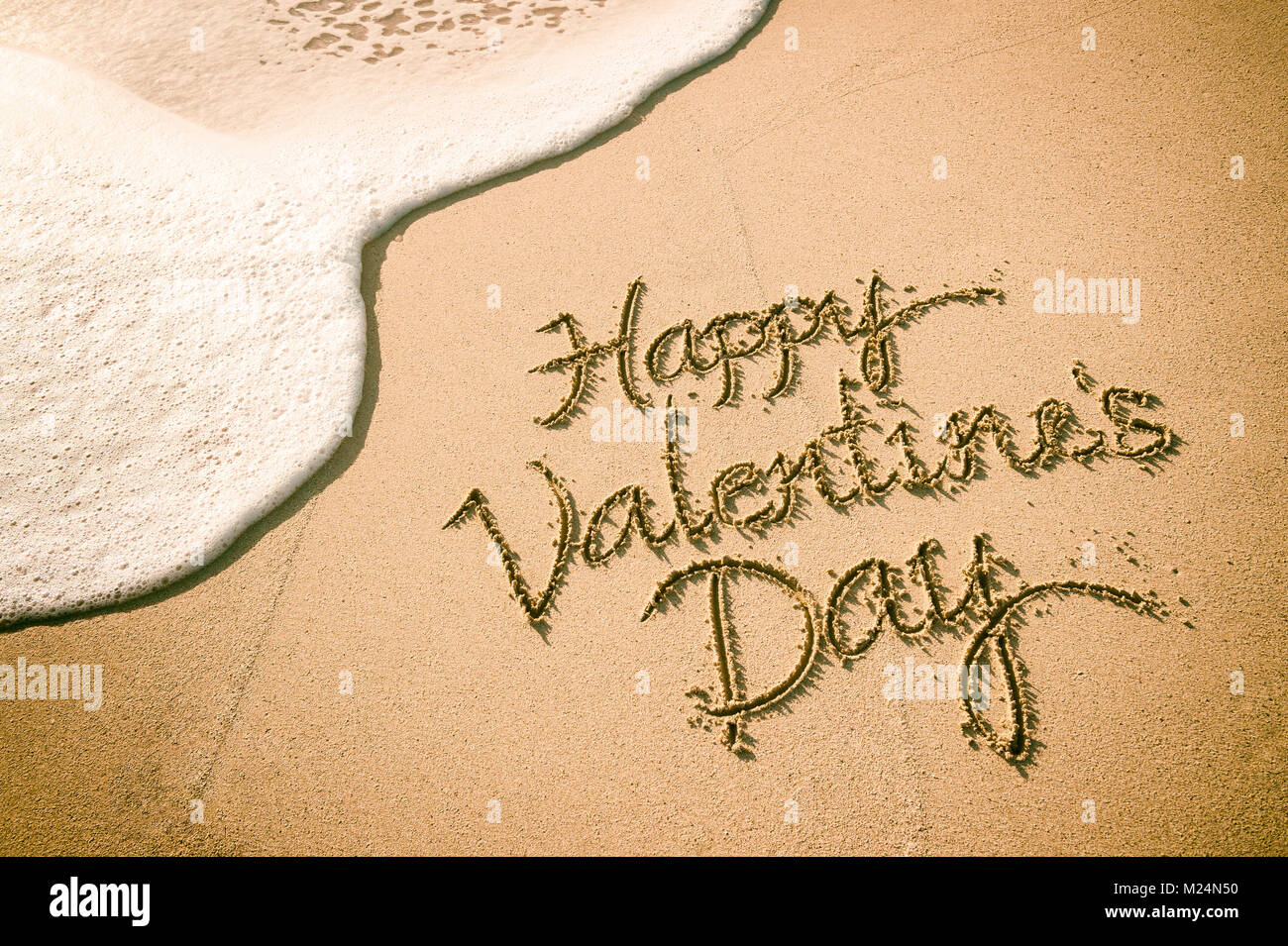 Happy Valentine's Day message handwritten on smooth sand beach Stock ...