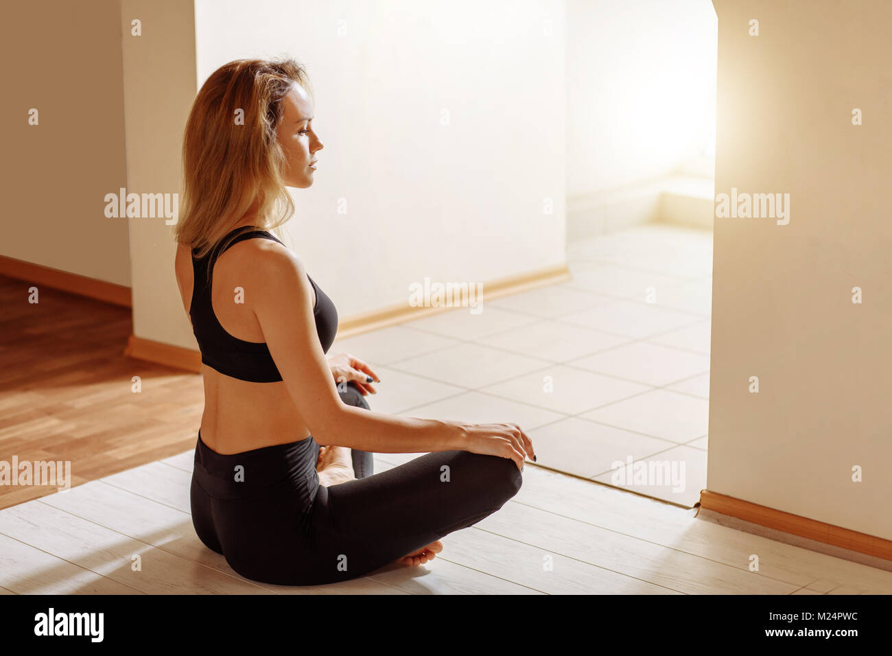 Beautiful woman sitting in lotus pose and meditating at yoga studio ...