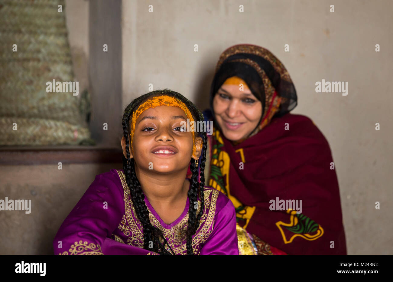 Nizwa, Oman, February 2nd, 2018: old Omani woman braiding her daughter's hair Stock Photo