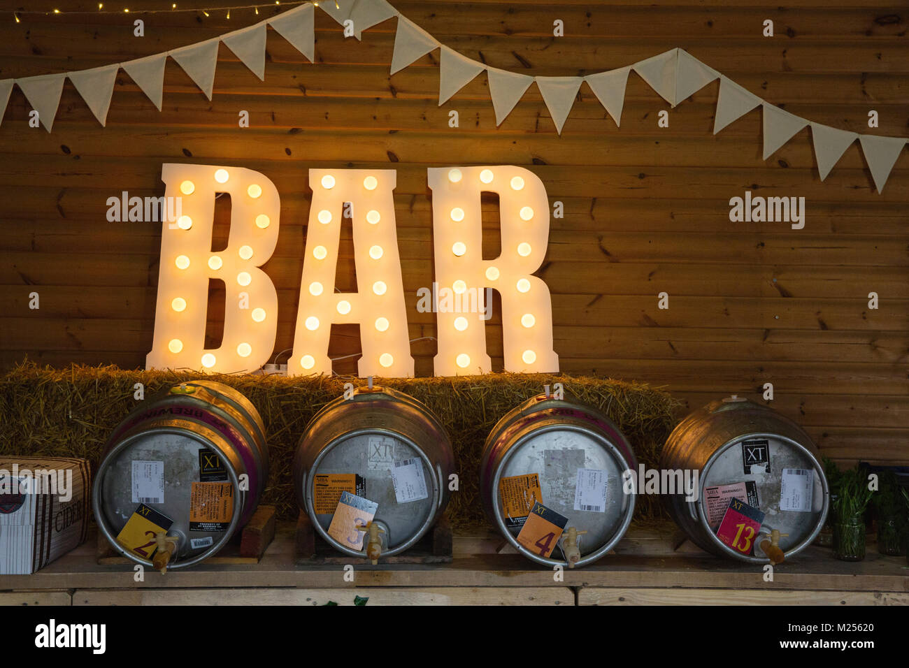 Barn with bunting, beer barrels and illuminated bar sign Stock Photo
