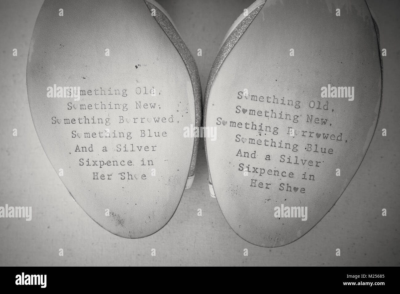 Wedding rhyme imprinted on soles of brides shoes, close up, black and white image Stock Photo