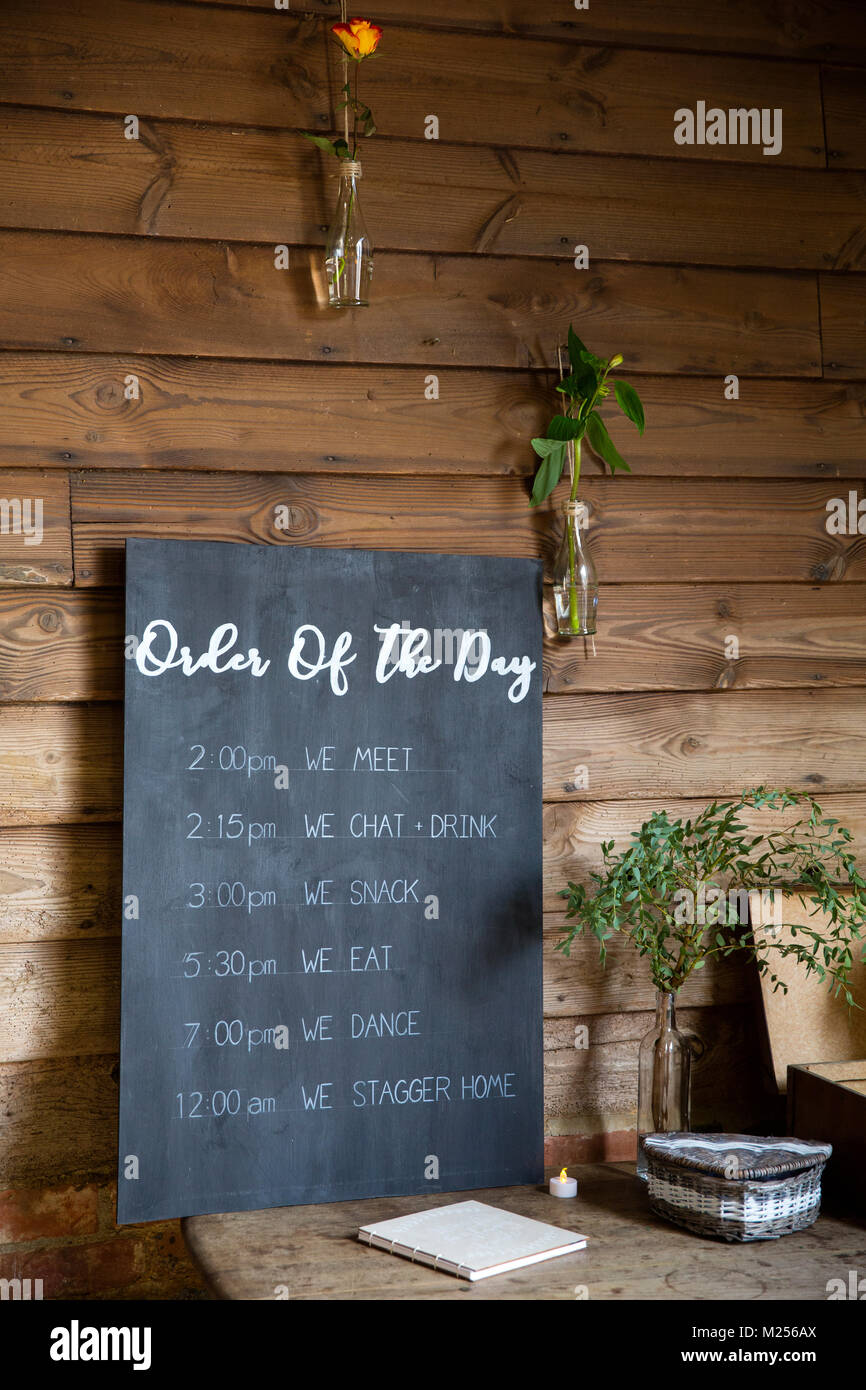 'Order of the day' Blackboard sign at barn wedding reception Stock Photo