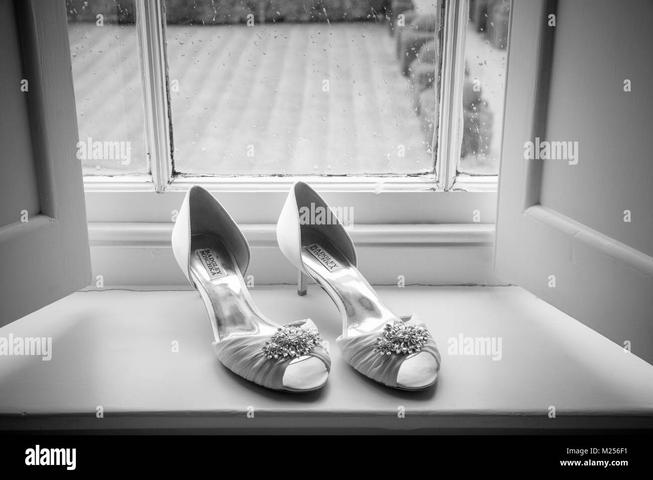 Bridal wedding shoes on windowsill, black and white image Stock Photo